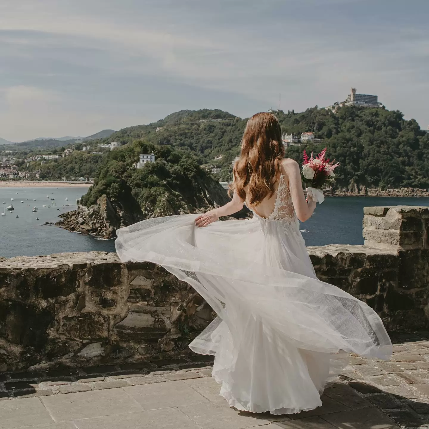 Фото. Невеста бежит к морю с букетом цветов и развивающемся платье.