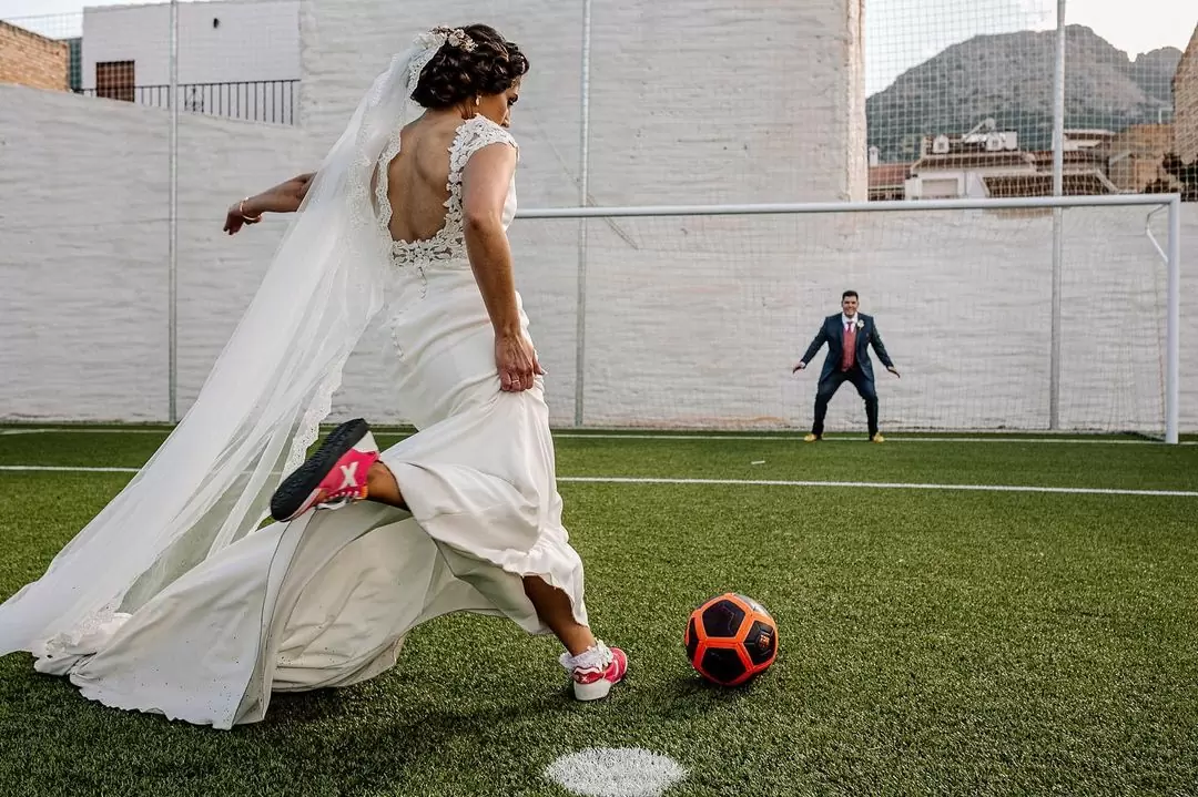 Фото. Невеста в красных бутсах играет в футбол