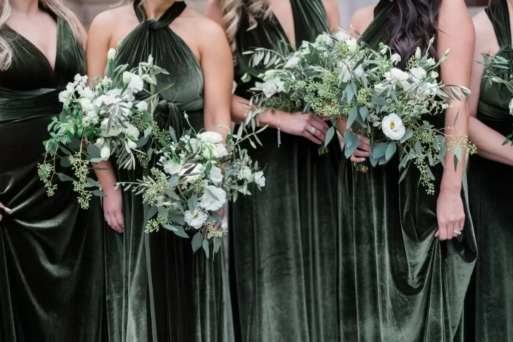 На фото подружки невесты в платьях в цвете Базилик (Basil) с букетами цветов. 