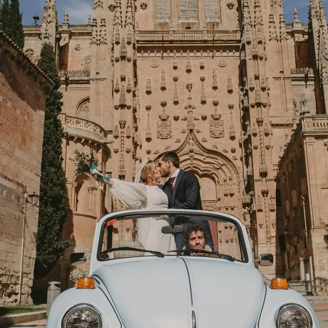 Фото. жених и невеста целуются в ретро-авто с открытым верхом на фоне МГУ