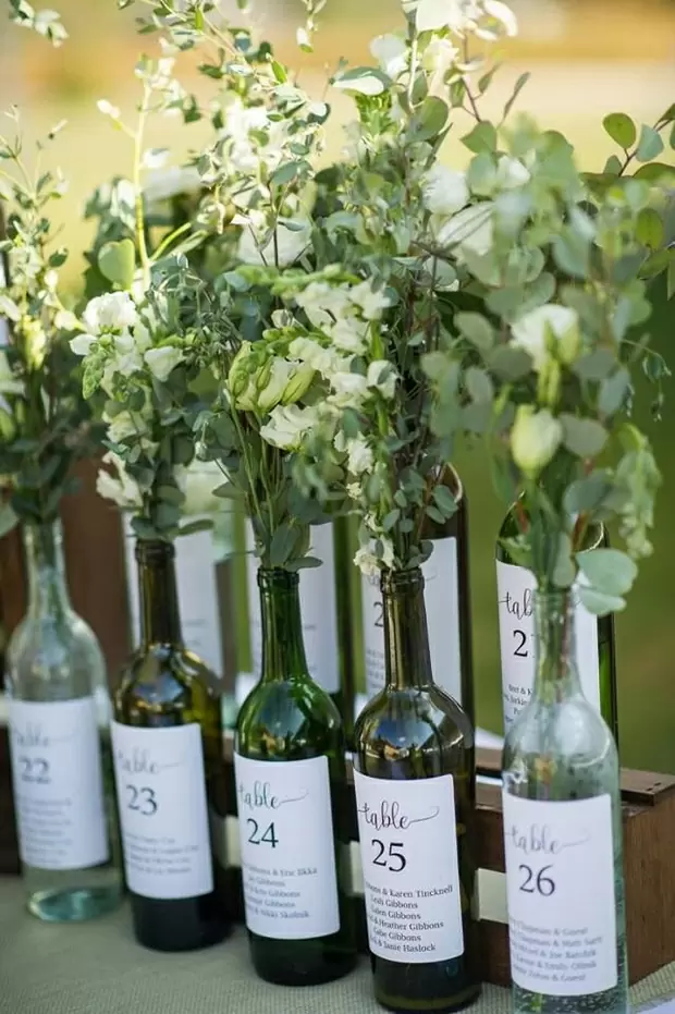Мини бутылочки с вином украшены живыми цветами