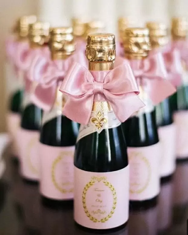 Шампанское украшено розовой лентой