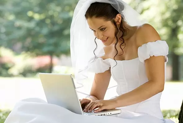 Фото. Невеста сидит за ноутбуком.