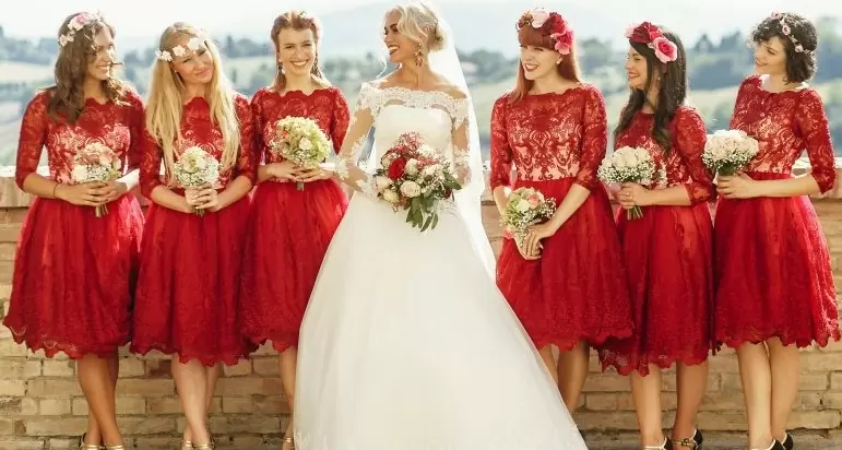Фото девушек в одинаковых красных платьях с букетами цветов, а невеста в белом.