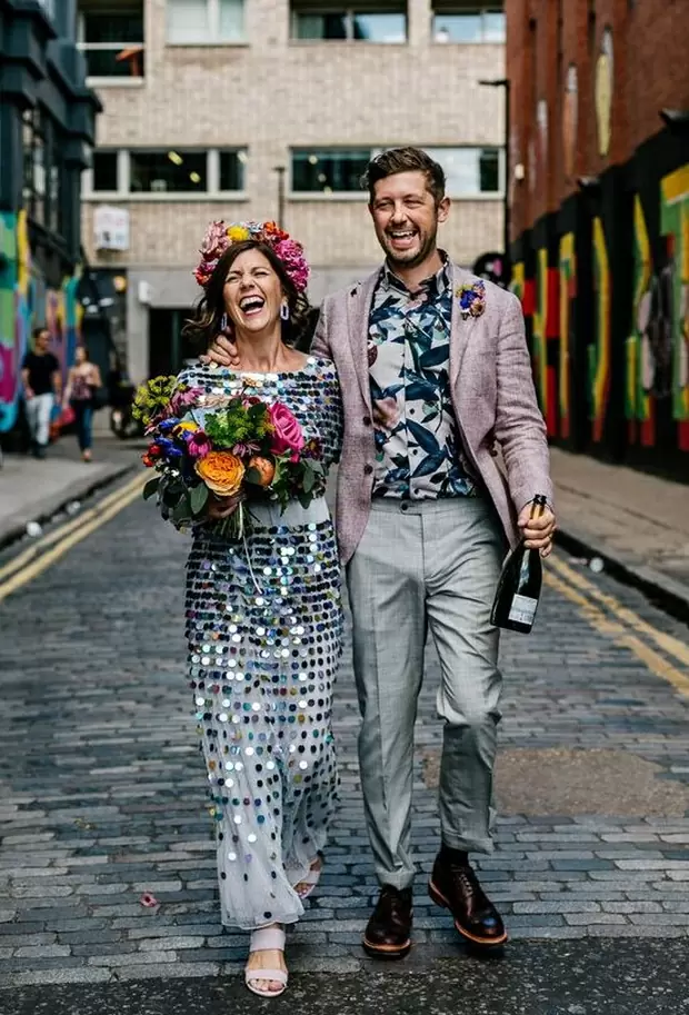 Фото . Невеста в венке и в веселом платье с блесками идет по улице вместе с женихом